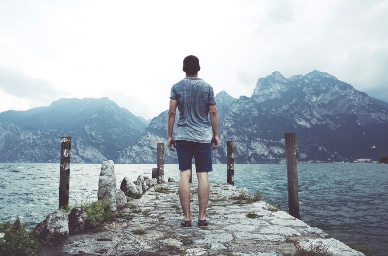 Entrepreneur standing alone facing a mountain