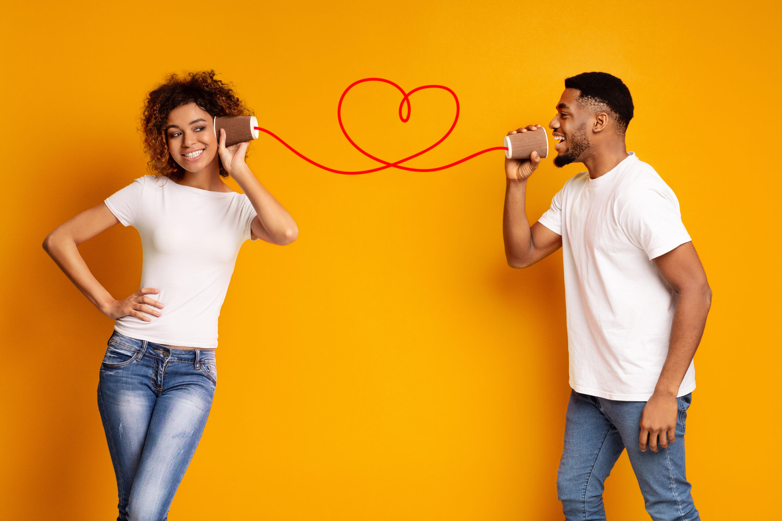 couple talking through cans connected by string shaped in a heart