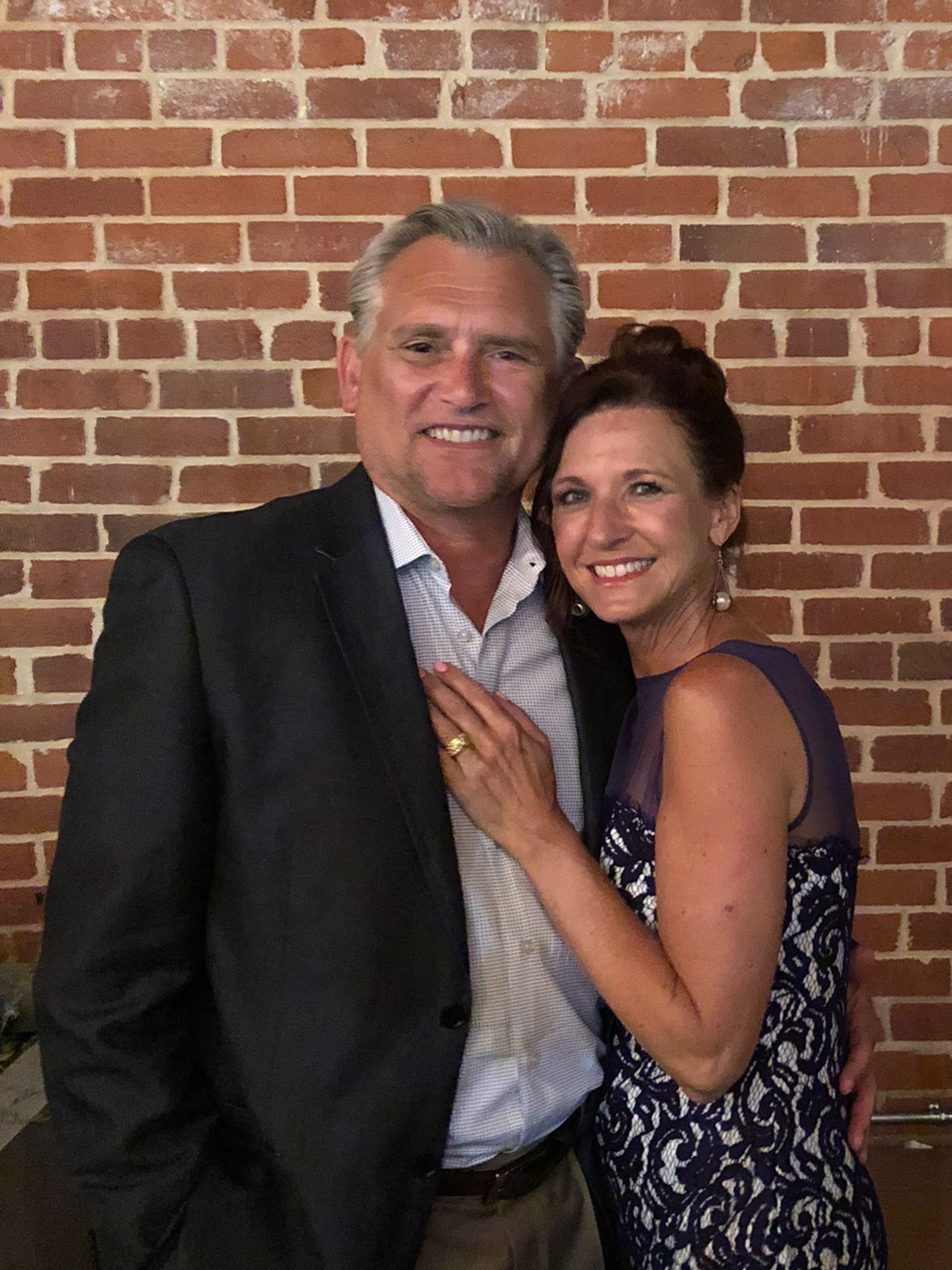 middle aged white couple smiling, dressed up