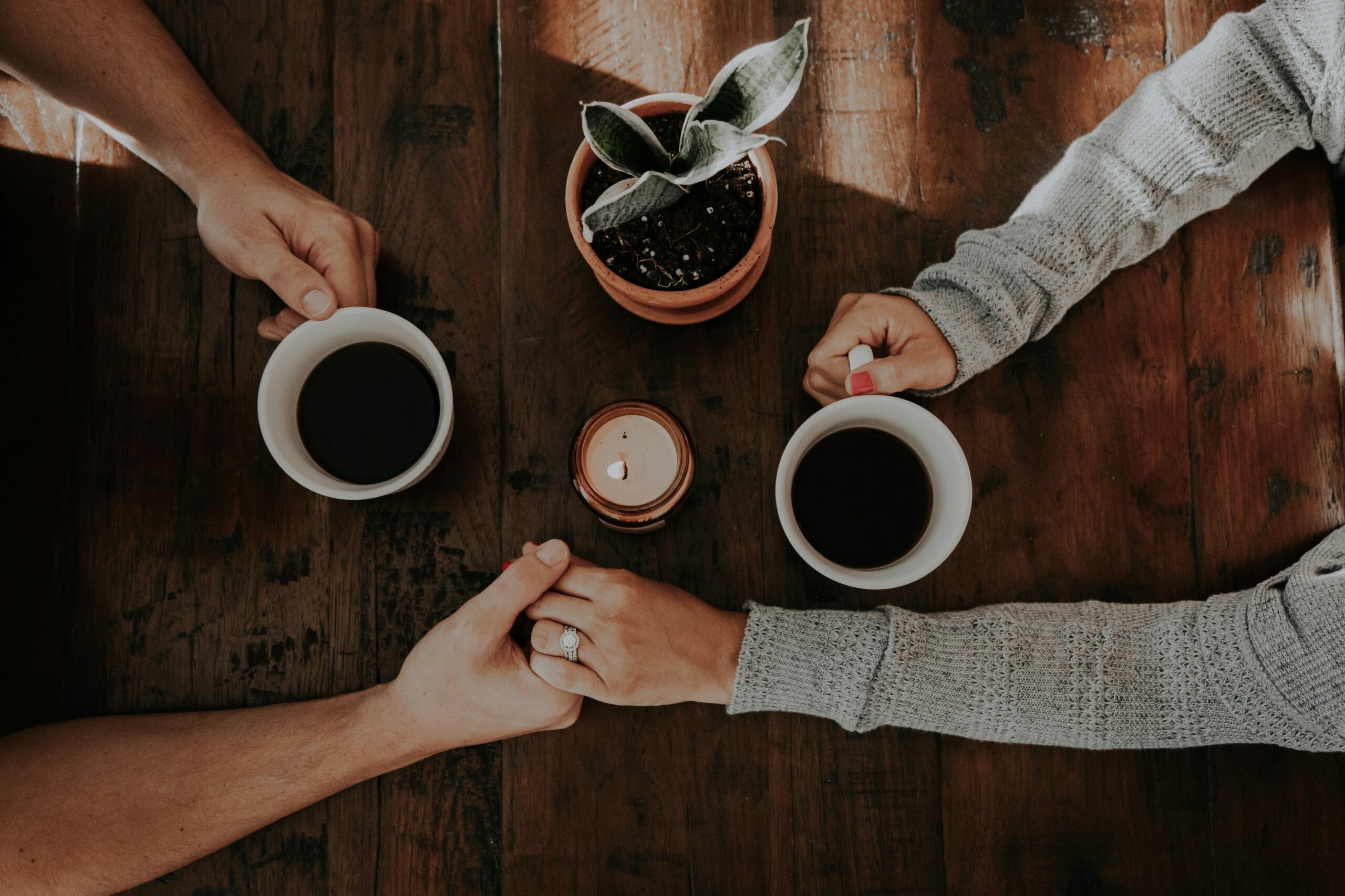 couple holding hands after apology that repairs relationship, professional relationship coach